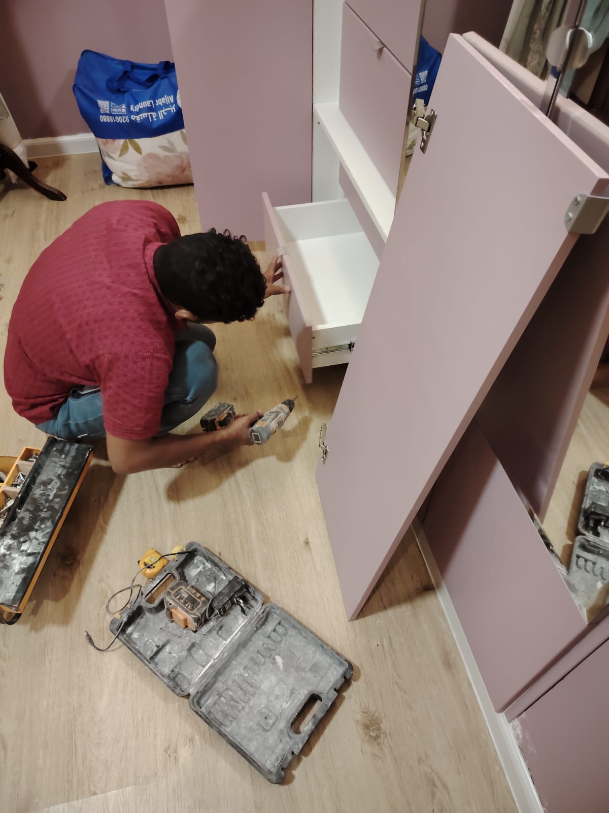 فني خبير أثناء عملية تصليح مطابخ بجدة، يقوم باستبدال المفصلات القديمة ومعالجة تآكل الأرفف وإعادة ضبط توازن الأدراج لضمان سلاسة الاستخدام اليومي 